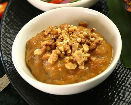 bowl with brownish sauce and peanuts on top