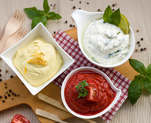 3 bowls of sauces , red, yello and white