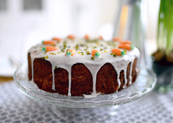 carrot cake on plate with oranage frosting carrots