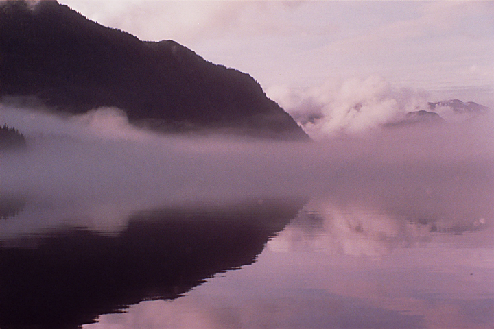 pink foggy reflection with dark hill in alaska