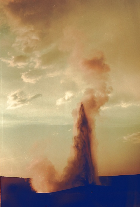 old faithful yellowstone national park erupting at sunset