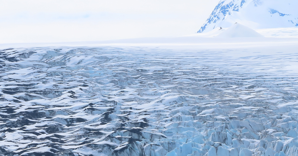 Top of glacier crevasses of blue and white and black glacier bay alaska