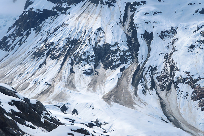 Mountain side in Alaska with dirty trails from landslides